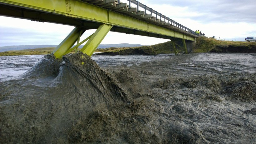 Skaftá er í gríðarleg­um ham, svört af aur og æðir yfir grasi gróna bakka sína.