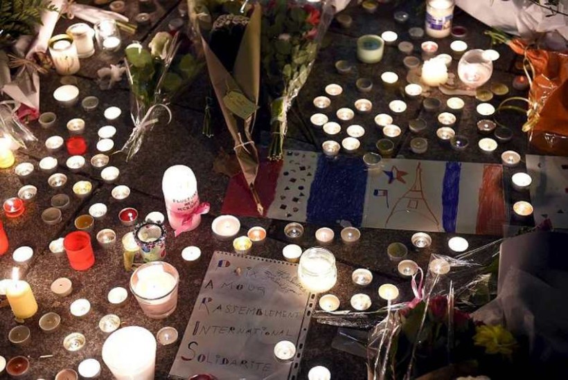 Flowers and candles are pictured near the Bataclan concert hall on November 14, 2015 in Paris, a day after a series of coordinated attacks in and around Paris. Islamic State jihadists claimed a series of coordinated attacks by gunmen and suicide bombers in Paris that killed at least 129 people in scenes of carnage at a concert hall, restaurants and the national stadium. AFP PHOTO / FRANCK FIFE