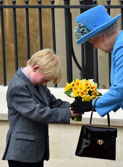 Elísabet drottning fékk blómvönd frá barni eftir guðsþjónustu í kapellu St. George við Windsor-kastala í London í dag. 