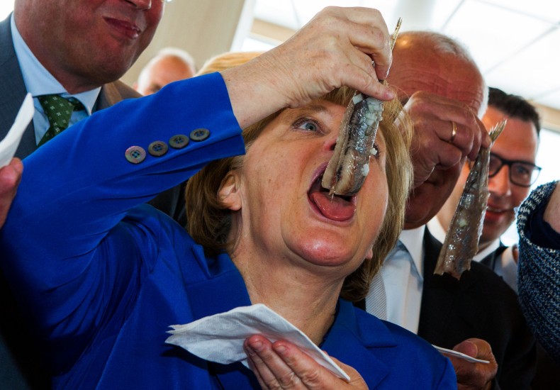 Angela Merkel kanslari Þýskalands rennir niður síld á fiskihátíð í austurhluta Þýskalands.