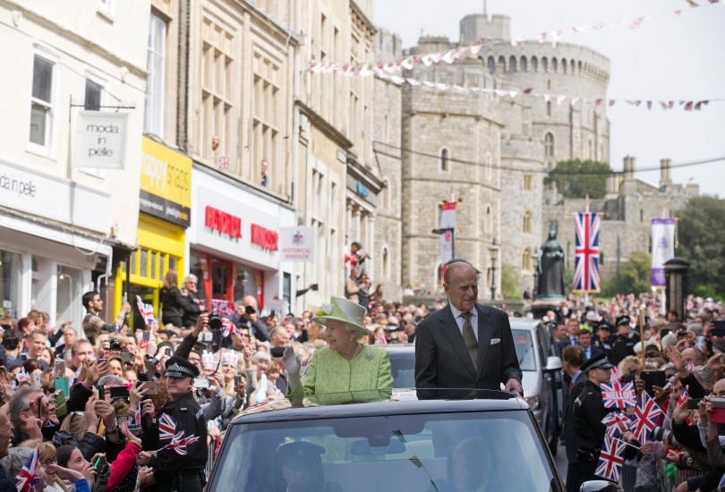 Elísabet Bretlandsdrottning og Filippus drottningarmaður veifa til þegnanna á leið til Windsor-kastala í dag.