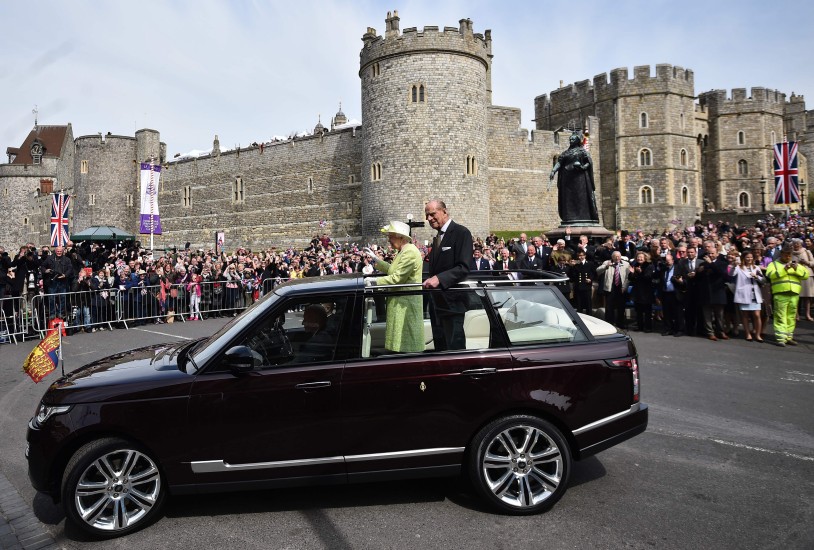 Elísabet Bretlandsdrottning og Filippus drottningarmaður veifa til þegnanna við Windsor-kastala í dag.